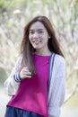 Toothy smiling face of beautiful asian younger woman standing in park Royalty Free Stock Photo