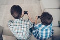 Top above high angle view portrait of two nice guys dad and pre-teen son sitting on sofa enjoying playing video game Royalty Free Stock Photo