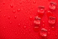 Top above overhead close up macro view photo of melting ice cubes on bright vivid color red background with drops Royalty Free Stock Photo