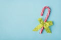 Top above overhead close up view flatlay photo of traditional single candy cane with green decorated dotted bow isolated over