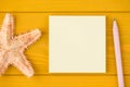 Top above overhead view close-up cropped photo of starfish blank note and pencil isolated on yellow wooden background with Royalty Free Stock Photo