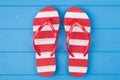 Top above overhead view close-up photo of a pair of red and white striped flipflops in center isolated on blue wooden background Royalty Free Stock Photo