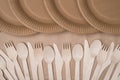 Top above overhead view cropped close-up photo of rows of wooden cutlery and paper plates isolated on craft paper background table
