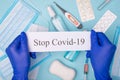 Top above overhead view photo of hands in gloves holding message stop covid-19 with masks sanitizer pills soap and shots isolated Royalty Free Stock Photo