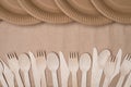 Top above overhead view photo of rows of wooden cutlery and paper plates isolated on craft paper background table