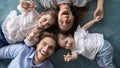 Happy young parents relaxing on bed with joyful little daughters. Royalty Free Stock Photo