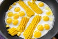 Top above view of many tasty healthy small chicken quail eggs with boiled corn slice fried on pan. bright yellow and Royalty Free Stock Photo