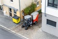 Top above view of small sweeping vacuum cleaner machine equipment removing dust rubbish city street sidewalk paved road