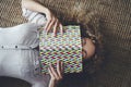 Top above view of tired woman asleep on the carpet at home with notebook or book covering her face. People sleeping on the floor