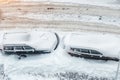 Top aerial view of apartment office building parking lot with many cars covered by snow stucked after heavy blizzard snowfall Royalty Free Stock Photo