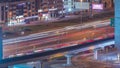 Top aerial view of busy road intersection and traffic junctions in Dubai city night timelapse.