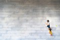 Top aerial view of family and kid people walking on pedestrian concrete grey block street pavement. Concept aerial view