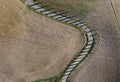 Top aerial view road surraunded with cypresses running in plowed field. Classical Tuscany views and traveling concept Royalty Free Stock Photo