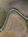 Top aerial view road surraunded with cypresses running in plowed field. Classical Tuscany views and traveling concept Royalty Free Stock Photo