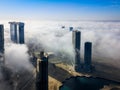 Top aerial view shot of skyscrapers in the city with fog clouds passing by - Abu Dhabi Al Reem island towers