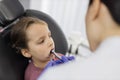 Girl lying on dentist chair with open mouth, female doctor curing her teeth, using dental drill. Royalty Free Stock Photo