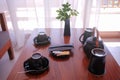 Tea / coffee set in black porcelain on wooden coffee table in tropical hotel resort room Royalty Free Stock Photo