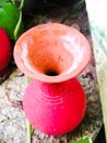 Top angle view of a vibrant red colored earthen pot placed on a brick