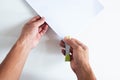 Top angle of young man right handed using green stapler