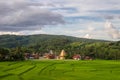 Green field with Wat Sri Pho Chai, background of mountains and blue sky in Na Haeo, Loei, Thailand