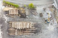Top birds eye view to stack of timber wood of sawmill with digger