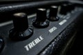 A top of a black guitar amplifier. treble, bass knobs. India