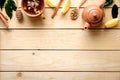 Top border or frame of cup of herbal tea, teapot, spoon of dried tea, lemon, cinnamon on wooden table. Top view, flat lay Royalty Free Stock Photo