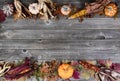 Top and bottom border of whole pumpkin, corn, acorns and foliage leaves on weathered wooden planks for the Autumn holiday season