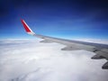View from airplane. Beautiful plane wing; over white clouds in the blue sky; taken through passenger window. Royalty Free Stock Photo