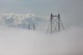 Top of the bridge stick out of the dense white fog