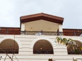 Top of the building with arched balconies with a triangular roof and lights on