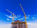 Top of a building with yellow cranes on a blue sky Royalty Free Stock Photo