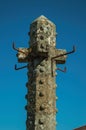 Top of carved stone pillory with blue sky in the background