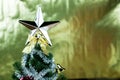 Top of Christmas tree decorated with star in bright golden shiny background Royalty Free Stock Photo