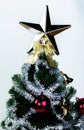 Top of Christmas tree decorated with star in bright white background Royalty Free Stock Photo