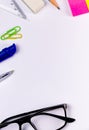 Top close up shot of stationary articles on a white surface with an eye glass for education and empowerment concept Royalty Free Stock Photo