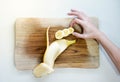 Top close up view of ripped banana cut in slices for breakfast bowl on top of a wooden cutting board in white background Royalty Free Stock Photo