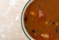 Top close view of a bowl of chicken tortilla soup on a marble table