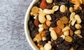 Top close view of a bowl filled with high energy trail mix on a gray mottled background in natural light