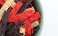 Top close view of colorful tortilla strips in a bowl