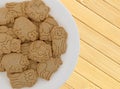 Plate of vanilla animal cookies on a wood place mat Royalty Free Stock Photo