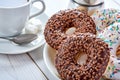 Top Closeup photo of sweet breakfast or snacks. Chocolate and vanilla donuts and cup of black coffee Royalty Free Stock Photo