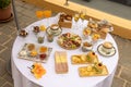 Top closeup of a round table outdoors with white tablecloth and burgers, chips, glasses of champagne Royalty Free Stock Photo