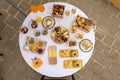 Top closeup of a round table outdoors with white tablecloth and burgers, chips, glasses of champagne Royalty Free Stock Photo