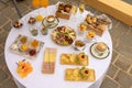 Top closeup of a round table outdoors with white tablecloth and burgers, chips, glasses of champagne Royalty Free Stock Photo