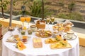 Top closeup of a round table outdoors with white tablecloth and burgers, chips, glasses of champagne Royalty Free Stock Photo