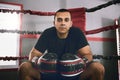 He is the top contender in town. Portrait of a confident young male boxer seated in the corner of a boxing ring at a gym Royalty Free Stock Photo