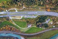Top dawn aerial view of freeway speed road between yellow autumn forest trees and blue river Royalty Free Stock Photo