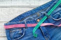 Top of denim trousers, on a wooden background. jeans with a measuring tape