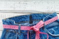 Top of denim trousers, on a wooden background. jeans with a measuring tape
